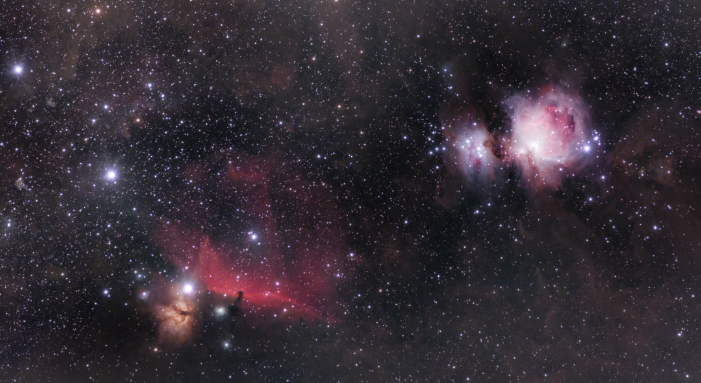 A pink and black photo from space of the Orion, Horsehead, and Flame nebula.